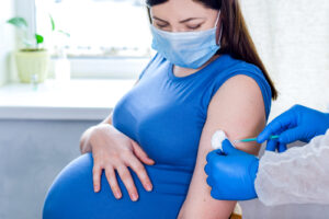  Pregnant woman In face mask getting vaccinated